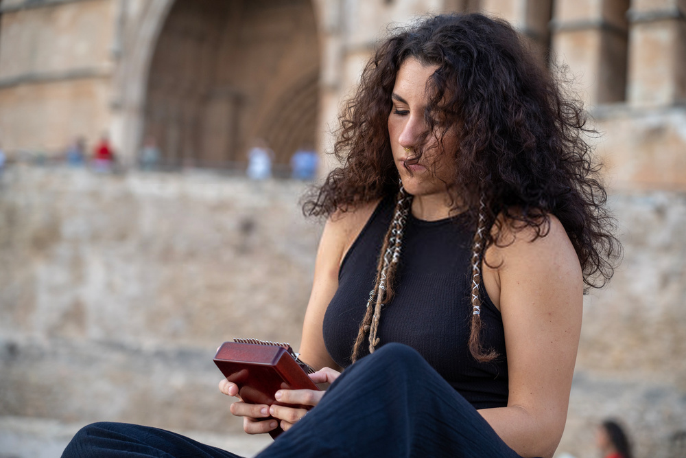 Femme jouant du kalimba en bois, instrument de musique africain traditionnel, en plein air