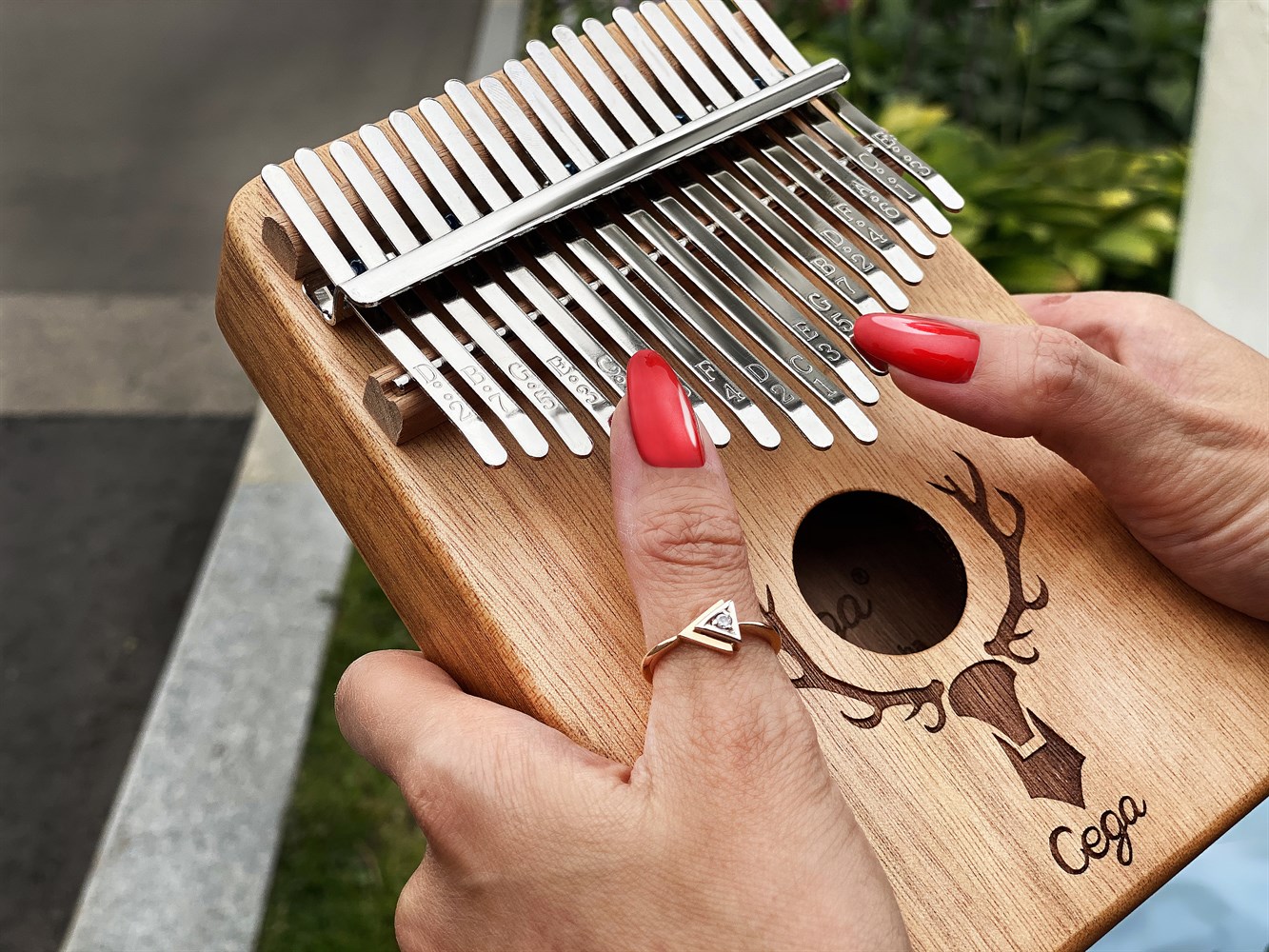 Mains jouant un kalimba en bois Cega avec des lames métalliques, instrument de musique africain mélodique